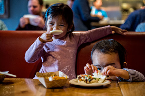 Grace Le (right) and Claire Tran eat during the Lunar New Year Celebration at Makan in Decatur on Saturday, February 6, 2016. 