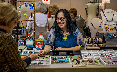 Nikki Thornburg-Lanigan (center) talks to Margaret Lasko as she shops at her booth during the Intergalactic Bead Show at the Infinite Energy Center in Duluth on Saturday, February 6, 2016. 