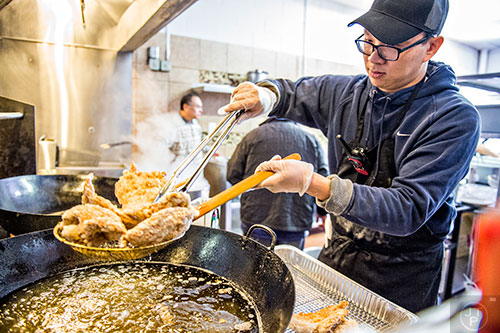 Jerry Wu fries chicken in a giant wok during the Atlanta Chinese Lunar New Year Festival in Chamblee on Saturday, February 13, 2016.