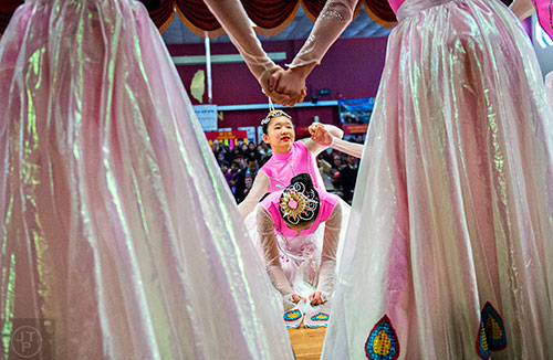 Jessie Wong (center) kneels down as Christabel Flagg and others dance around her on stage during the Atlanta Chinese Lunar New Year Festival in Chamblee on Saturday, February 13, 2016. 