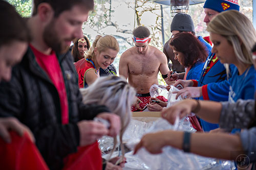 Jordan Spivack (center) seals his clothes in a plastic bag after registering for the 2016 Cupid Undie Run at Big Sky in Buckhead on Saturday, February 13, 2016. 