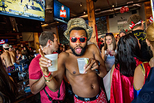 Corey Dortch (center) carries drinks in both hands as he makes his way through the crowd before the start of the 2016 Cupid Undie Run at Big Sky in Buckhead on Saturday, February 13, 2016. 