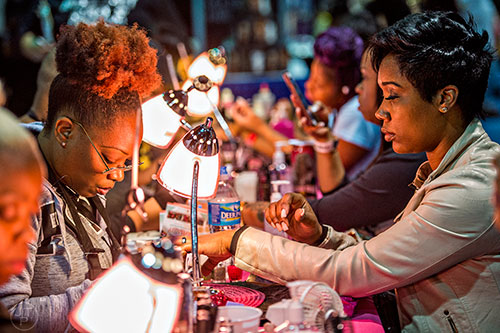 Robbie Green (left) works on Tiffanie Chavers' nails during the Bronner Brothers International Beauty Show at the Georgia World Congress Center in Atlanta on Saturday, February 20, 2016.