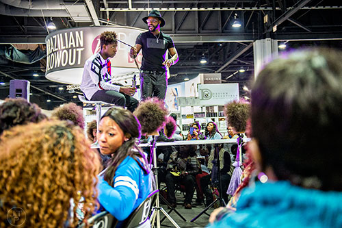Damian Walter (center) demonstrates how to apply dreadlock extensions to Jaylon Smith's hair during the Bronner Brothers International Beauty Show at the Georgia World Congress Center in Atlanta on Saturday, February 20, 2016. 