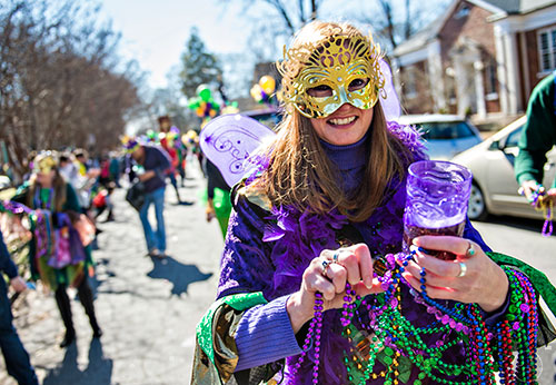 Amber Hall works to detangle a bunch of beads during the first annual LantaGras Parade in Kirkwood on Saturday.