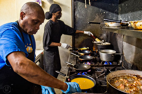 Derrick Cooper (left) and Paul Marlon man the stoves as they cook orders at Home grown off of Memorial Drive in Atlanta.