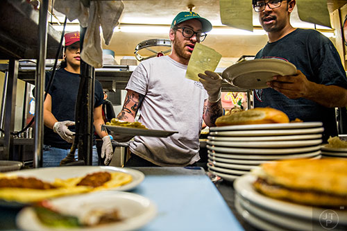 Jackie Ruvalcaba (left), Wes Moore and Kamen Miller make sure that orders are correct before they leave the kitchen at Home grown off of Memorial Drive in Atlanta.