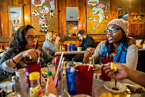 Kaya Forstall (left) and Kristen Williams (right) eat breakfast as Emery Wach and Matthew Phillips wait to order at Home grown off of Memorial Drive in Atlanta.