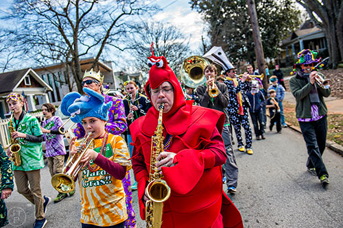 Matt Smith (center) plays his saxophone during the Mead Rd. Mardi Gras Parade on Saturday.