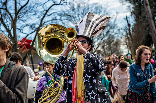 Bo Emerson (center) plays his trumpet during the Mead Rd. Mardi Gras Parade on Saturday.