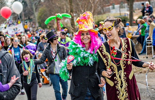 Genia Cayce (right) and Kathy Hall march during the Mead Rd. Mardi Gras Parade on Saturday.