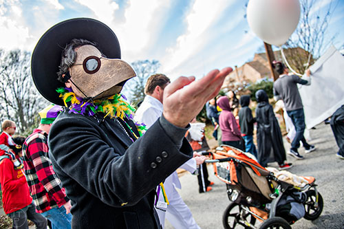 Dan Payne (left) tosses beads to the crowd during the Mead Rd. Mardi Gras Parade on Saturday.