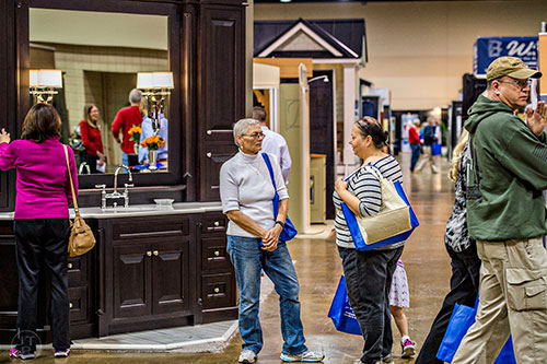 Fran Blackburn (center) talks to Chris Saunders as people walk the aisles during the North Atlanta Home Show at the Infinite Energy Center in Duluth on Saturday, February 20, 2016. 