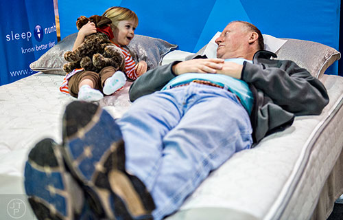 Lora Bucy (left) lays next to her grandfather John as he tries out a sleep number bed during the North Atlanta Home Show at the Infinite Energy Center in Duluth on Saturday, February 20, 2016. 