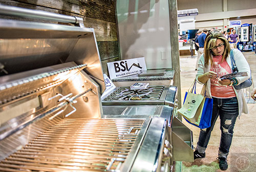 Stacie Hawkins (right) looks at information on different grills during the North Atlanta Home Show at the Infinite Energy Center in Duluth on Saturday, February 20, 2016.