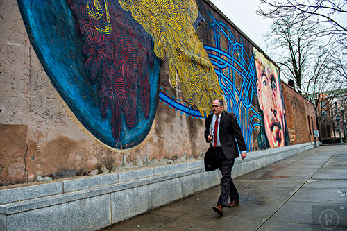Matthew Carlton walks past the mural in downtown Decatur on Tuesday, February 23, 2016. 