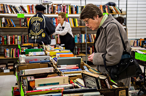 Pam Raines looks at different books for sale during the 25th annual Sandy Springs Society Tossed Out Treasures sale at Marshall's Plaza in Sandy Springs on Saturday, February 27, 2016. 
