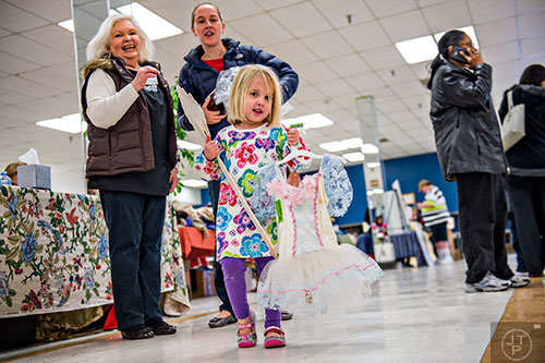 Abby Thompson (center) carries her dress as she shops with her mother Tia and grandmother Elizabeth during the 25th annual Sandy Springs Society Tossed Out Treasures sale at Marshall's Plaza in Sandy Springs on Saturday, February 27, 2016. 