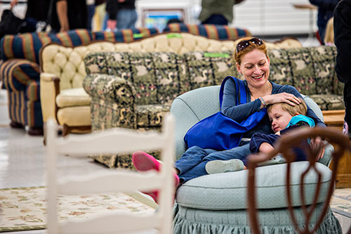 Michelle Baumann (left) sits in a chair with her son Bishop as they shop during the 25th annual Sandy Springs Society Tossed Out Treasures sale at Marshall's Plaza in Sandy Springs on Saturday, February 27, 2016. 