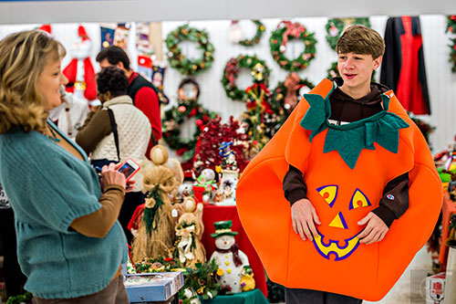 Auden Taylor (right) tries on a pumpkin costume for his mother Vicki Nash during the 25th annual Sandy Springs Society Tossed Out Treasures sale at Marshall's Plaza in Sandy Springs on Saturday, February 27, 2016. 