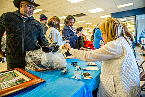 Rickey McCray (left) checks out with Gretchen Lehane during the 25th annual Sandy Springs Society Tossed Out Treasures sale at Marshall's Plaza in Sandy Springs on Saturday, February 27, 2016. 