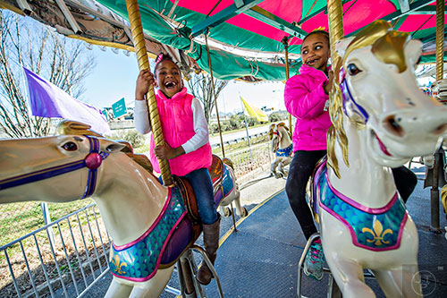 Sky Brown (left) and Kennedy Barnett ride the merry-go-round at the Atlanta Fair near Turner Field in downtown on Saturday, February 27, 2016. 