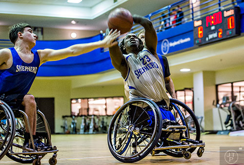 James Adams (right) shoots for two points as Brent O'Grady (left) leans in to try and block the shot during basketball practice at the Shepherd Center in Atlanta on Thursday, February 25, 2016. 