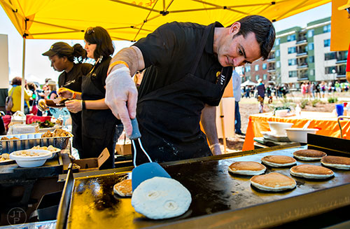 Bryan Fitzsimmons (center) checks to see if his pancake is ready to flip as he serves up brunch with Another Broken Egg Cafe at the Atlanta Brunch Festival at Fourth Ward Park in Atlanta on Saturday, March 5, 2016. 