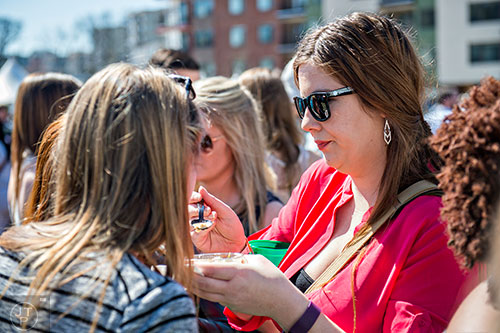 Alora Humann (right) gives a taste of her food to Ashley Madison during the Atlanta Brunch Festival at Fourth Ward Park in Atlanta on Saturday, March 5, 2016. 