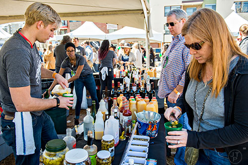 Heidi Russell (right) drops olives in her bloody mary as Chase Lovin (left) makes a drink for her husband Geoff during the Atlanta Brunch Festival at Fourth Ward Park in Atlanta on Saturday, March 5, 2016. 