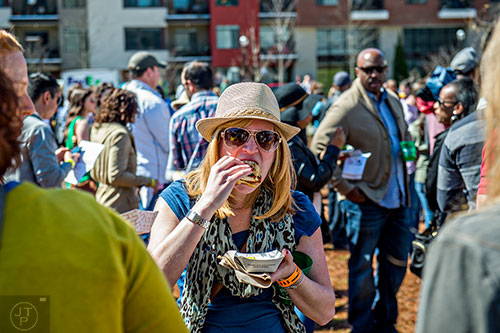 Lindsay Geist (center) takes a bite of her chicken biscuit during the Atlanta Brunch Festival at Fourth Ward Park in Atlanta on Saturday, March 5, 2016. 
