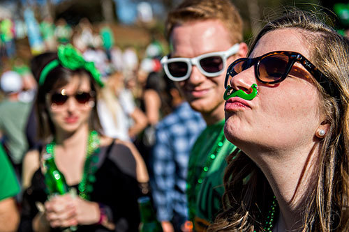 Amanda Nelson (right) tries to balance a mustache between her nose and upper lip without using her hands during LepreCon at Park Tavern in Atlanta on Saturday, March 5, 2016. 