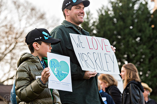 Isaiah Lewis (left) and his father Jeremy hold signs in support of Susan Riley as they stand across from Decatur High School during the Rally for Riley on Monday morning. Photo: Jonathan Phillips