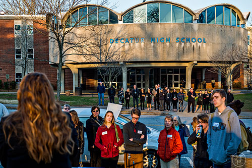 Teachers and faculty at Decatur High School stand in front of the school listening to an outpouring of support for Susan Riley during the Rally for Riley on Monday morning.