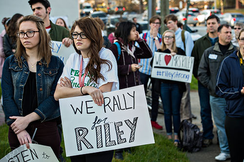 Braylen Dixon (left) and Abigail Gasparotti hold signs while they listen to speakers talk in support of Susan Riley during the Rally for Riley across from Decatur High School on Monday morning.