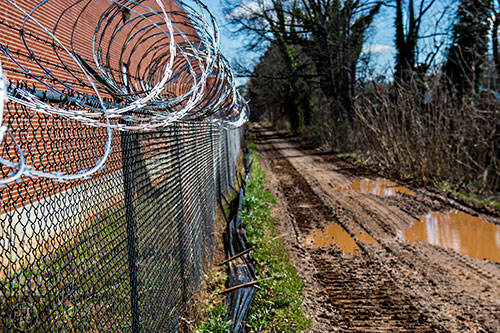 Razor wire runs along a section of the Westside Trail which is currently under construction.
