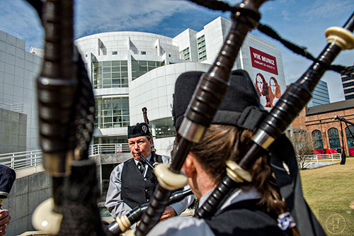Janice Summers (center) warms up with other members of the Atlanta Pipe Band in front of the High Museum of Art as they wait for the start of the annual St. Patrick's Day Parade on Saturday, March 12, 2016. 