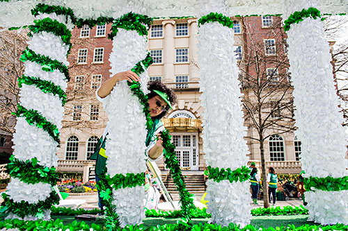 Lori Peavy (center) wraps shamrocks around columns on a parade float as she waits for the start of the annual Atlanta St. Patrick's Day Parade on Saturday, March 12, 2016. 