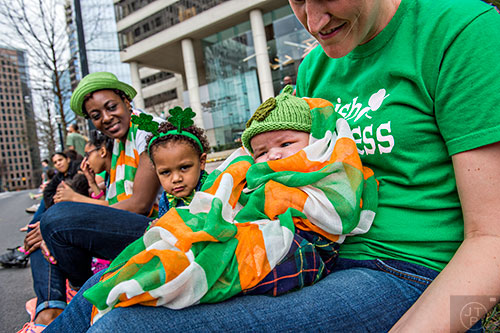 Daylen Cusick (center) sits in her mother Amanda's lap as they wait for the start of the annual Atlanta St. Patrick's Day Parade on Saturday, March 12, 2016. 