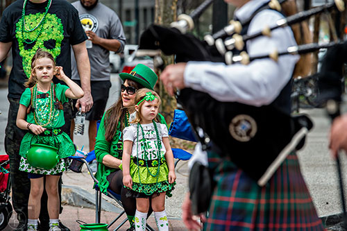 Sovianna Roberts (left), Teresa Harlan and Braeley Billingsley watch the Atholl Highlanders Pipes & Drums pass by during the annual Atlanta St. Patrick's Day Parade on Saturday, March 12, 2016. 