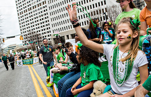 Stella Canty (right) throws beads to the crowd during the annual Atlanta St. Patrick's Day Parade on Saturday, March 12, 2016. 