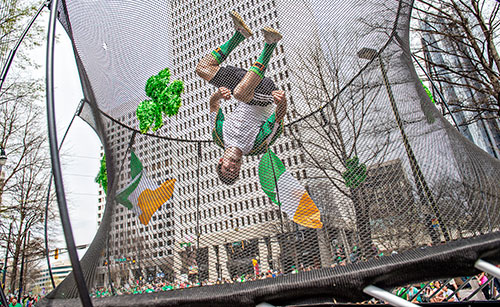 Ryan Walden flips upside down on a trampoline during the annual Atlanta St. Patrick's Day Parade on Saturday, March 12, 2016. 