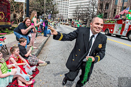 Atlanta firefighter Nick Bigler waves as he runs to catch up with his group during the annual Atlanta St. Patrick's Day Parade on Saturday, March 12, 2016. 