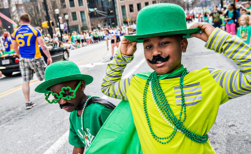 Gabriel Morgan (right) and his brother Micah watch the annual Atlanta St. Patrick's Day Parade pass by on Saturday, March 12, 2016. 