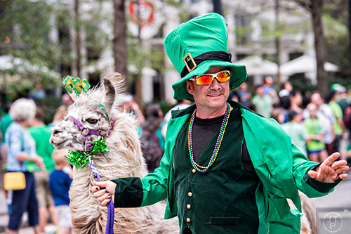 Scott Fretz leads Quinn the llama down Peachtree St. during the annual Atlanta St. Patrick's Day Parade on Saturday, March 12, 2016. 