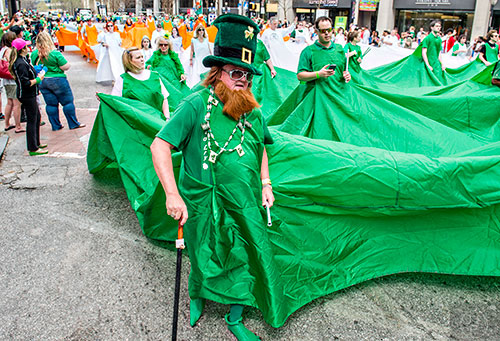Mike Thiery (center) marches down Peachtree St. with the large Irish flag during the annual Atlanta St. Patrick's Day Parade on Saturday, March 12, 2016. 