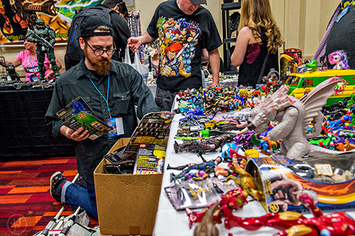 Nathan Morris (center) searches through a box of Star Wars figures during Joelanta and the Great Atlanta Toy Convention at the Marriott Century Center in Atlanta on Saturday, March 12, 2016. 