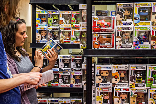 Leia Rogers (left) looks at a shelf of Pop! Television figures during Joelanta and the Great Atlanta Toy Convention at the Marriott Century Center in Atlanta on Saturday, March 12, 2016. 