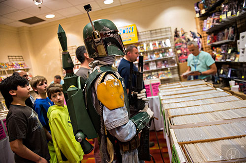 Dressed as Boba Fett, Caleb Cole (center) looks at different toys for sale during Joelanta and the Great Atlanta Toy Convention at the Marriott Century Center in Atlanta on Saturday, March 12, 2016. 