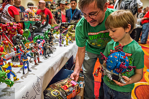Will Farmer (right) and his father Kenny look at different toys to purchase during Joelanta and the Great Atlanta Toy Convention at the Marriott Century Center in Atlanta on Saturday, March 12, 2016. 